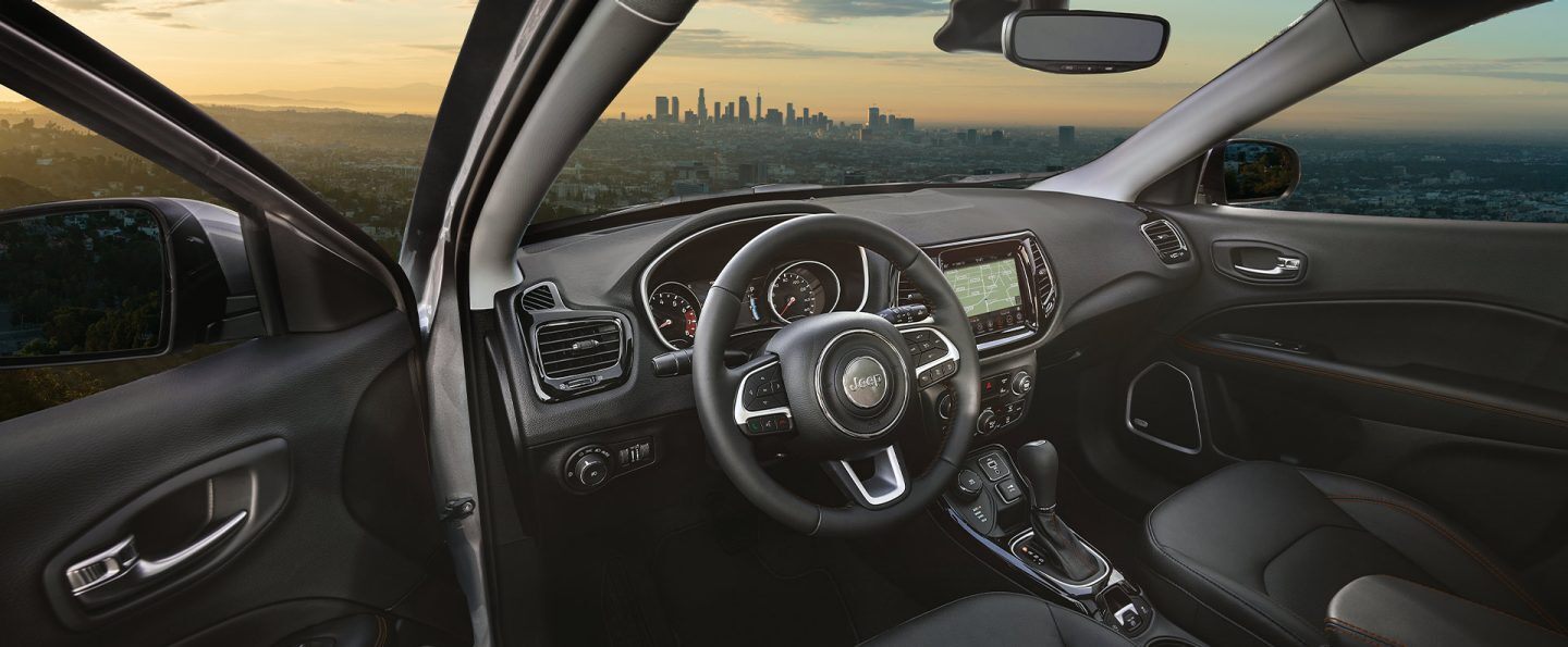 The front seat area of the 2021 Jeep Compass, focusing on the steering wheel and instrument panel.