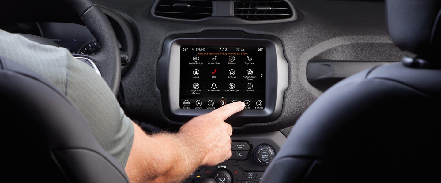 The Uconnect touchscreen in the 2021 Jeep Renegade with the driver making a selection.